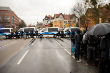 Demo steht vor Polizeisprerre und hört Redebeitrag zu